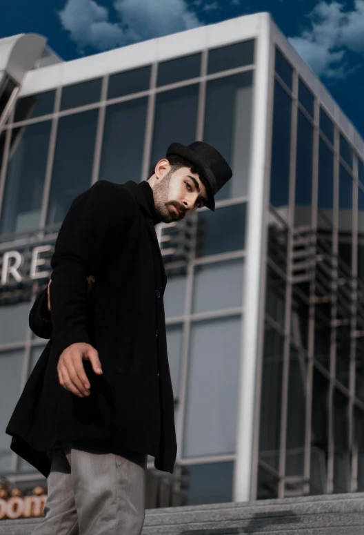 man on his phone on the steps in front of a large building