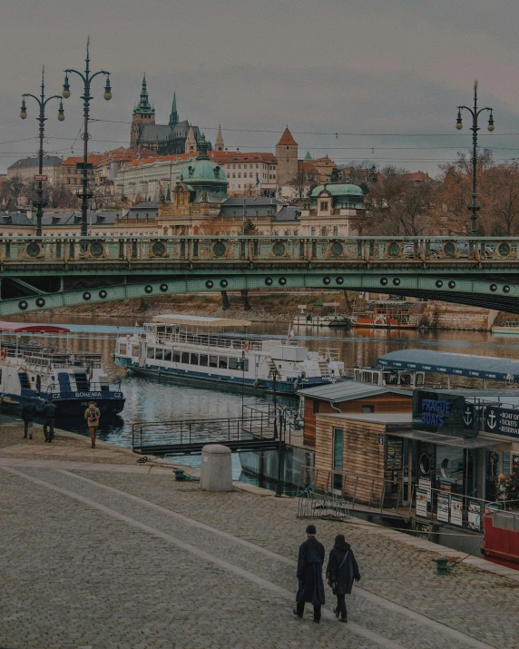 a group of people walking past a harbor filled with boats