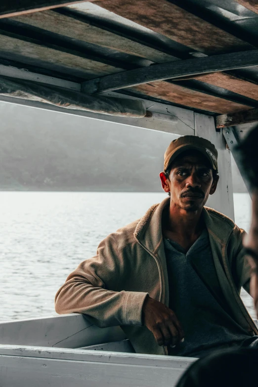 a man is sitting on a boat in the water