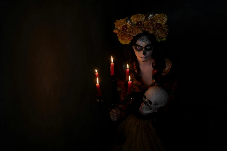 a woman wearing a skeleton mask with a lit candle in her hand