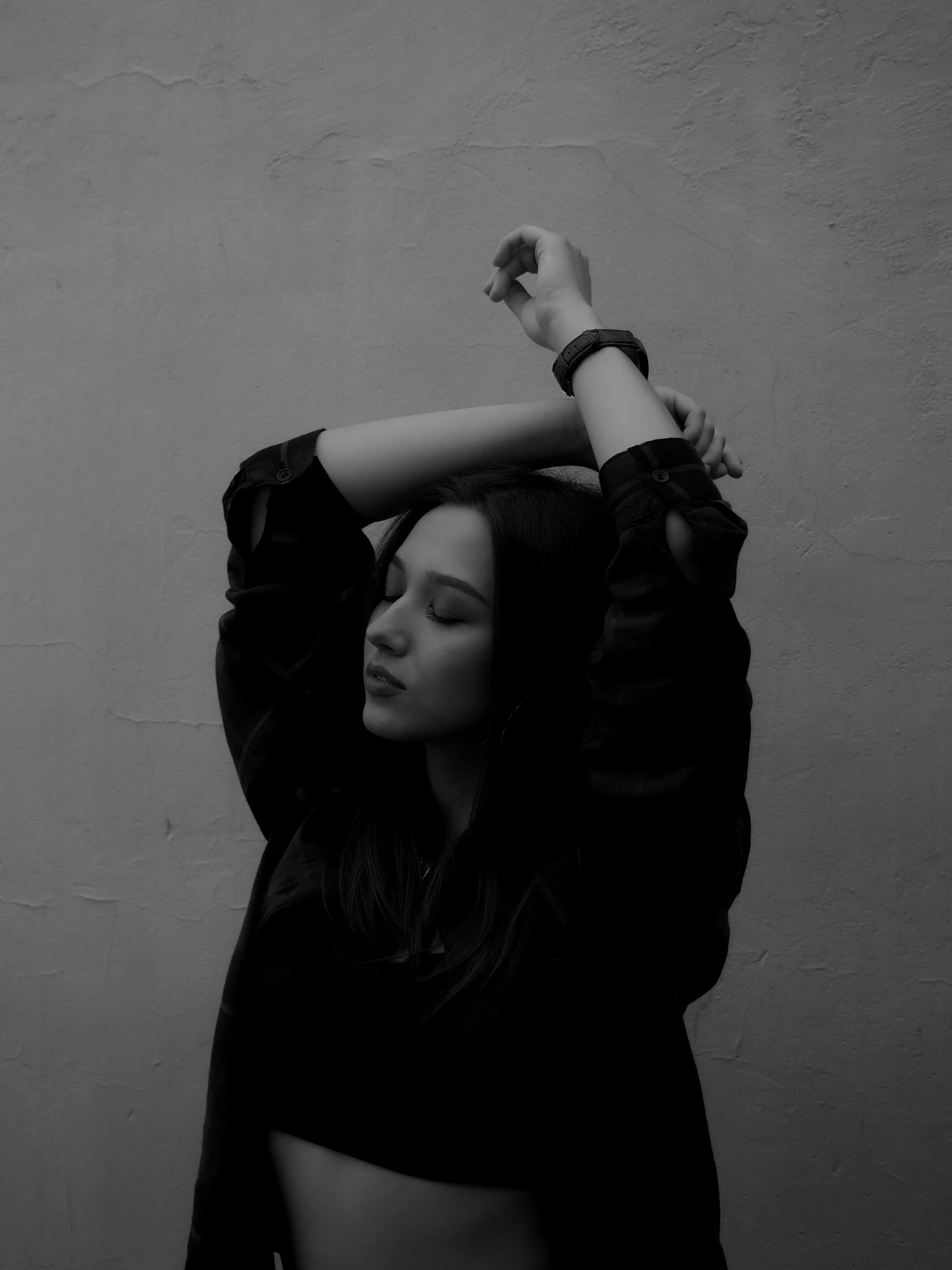 black and white pograph of a young woman with her arms above her head