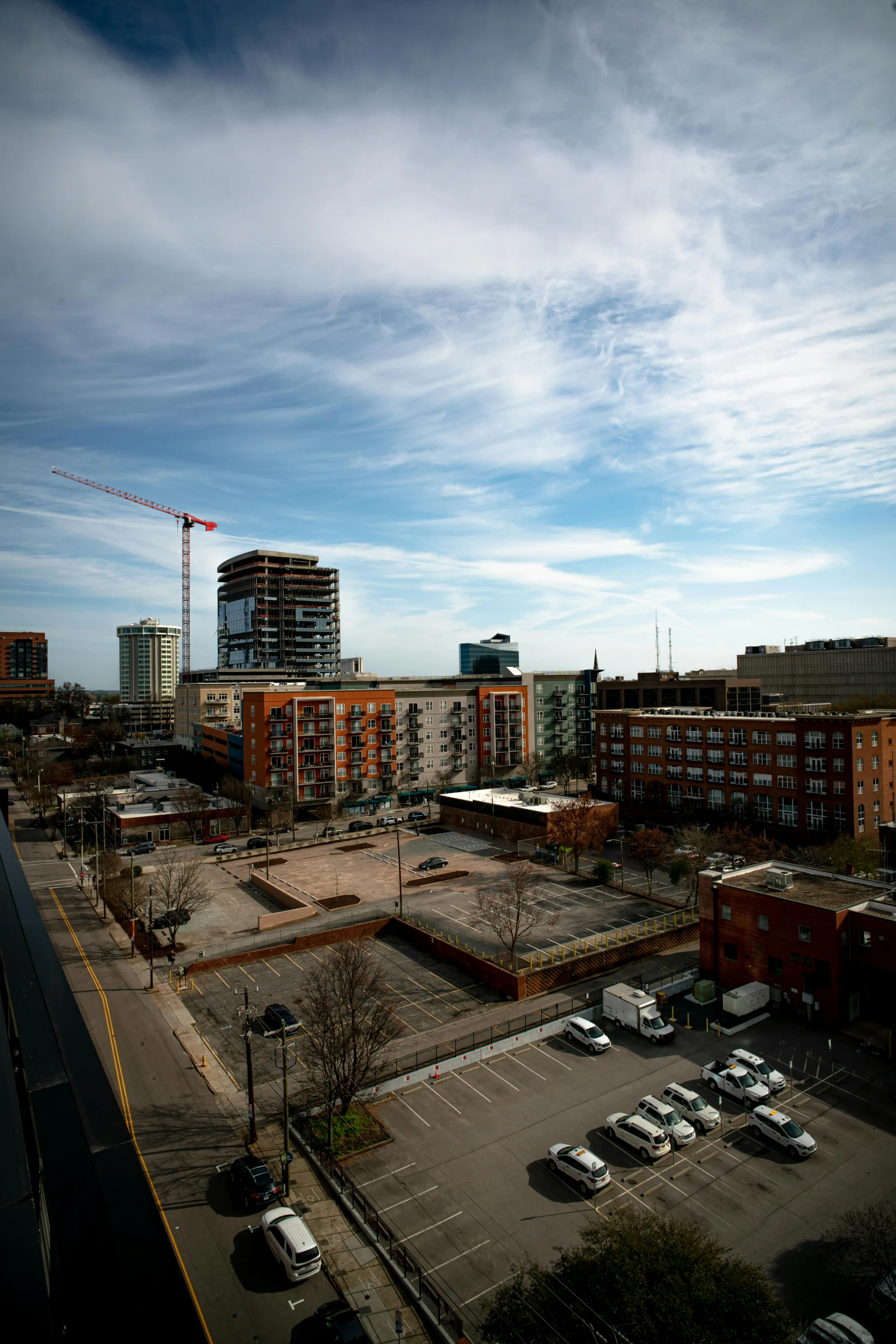 the view from a very high rise looking down at a parking lot