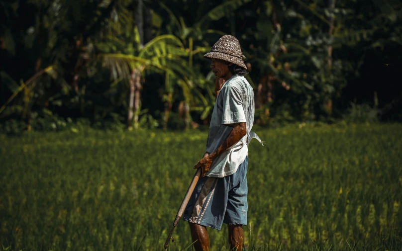 a man is standing in the grass with his boat