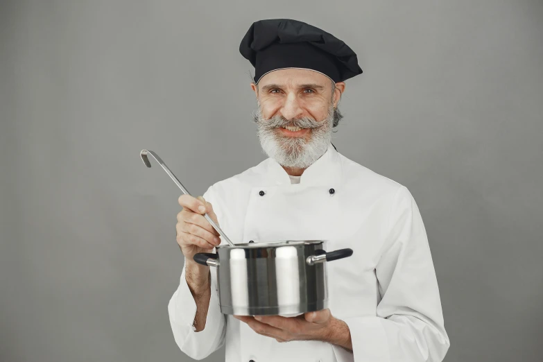 a man in chef outfit holding a pot with silverware