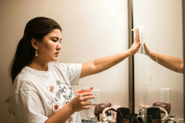 a person holding a cup up while looking in the mirror