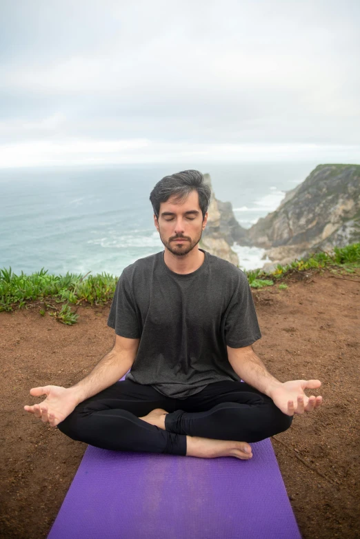 the man is meditating outside in a yoga pose