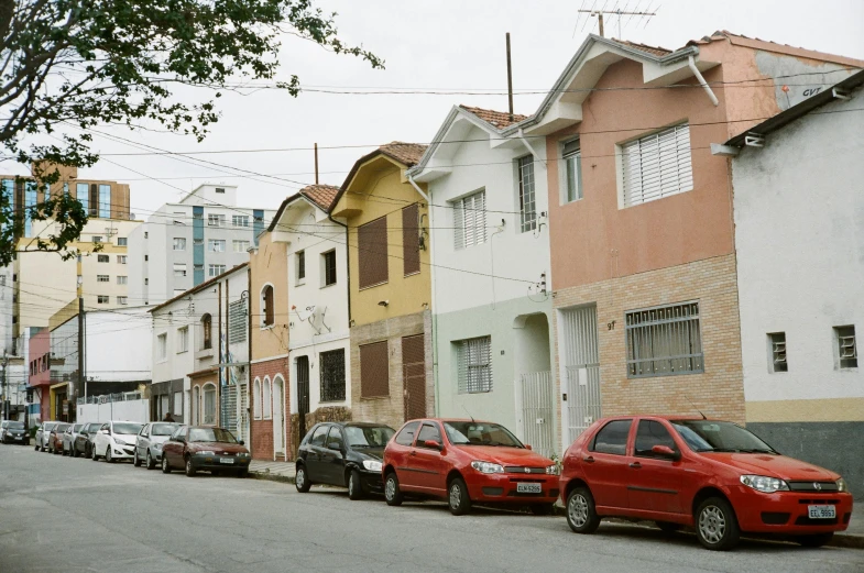 a row of houses with cars parked on the side