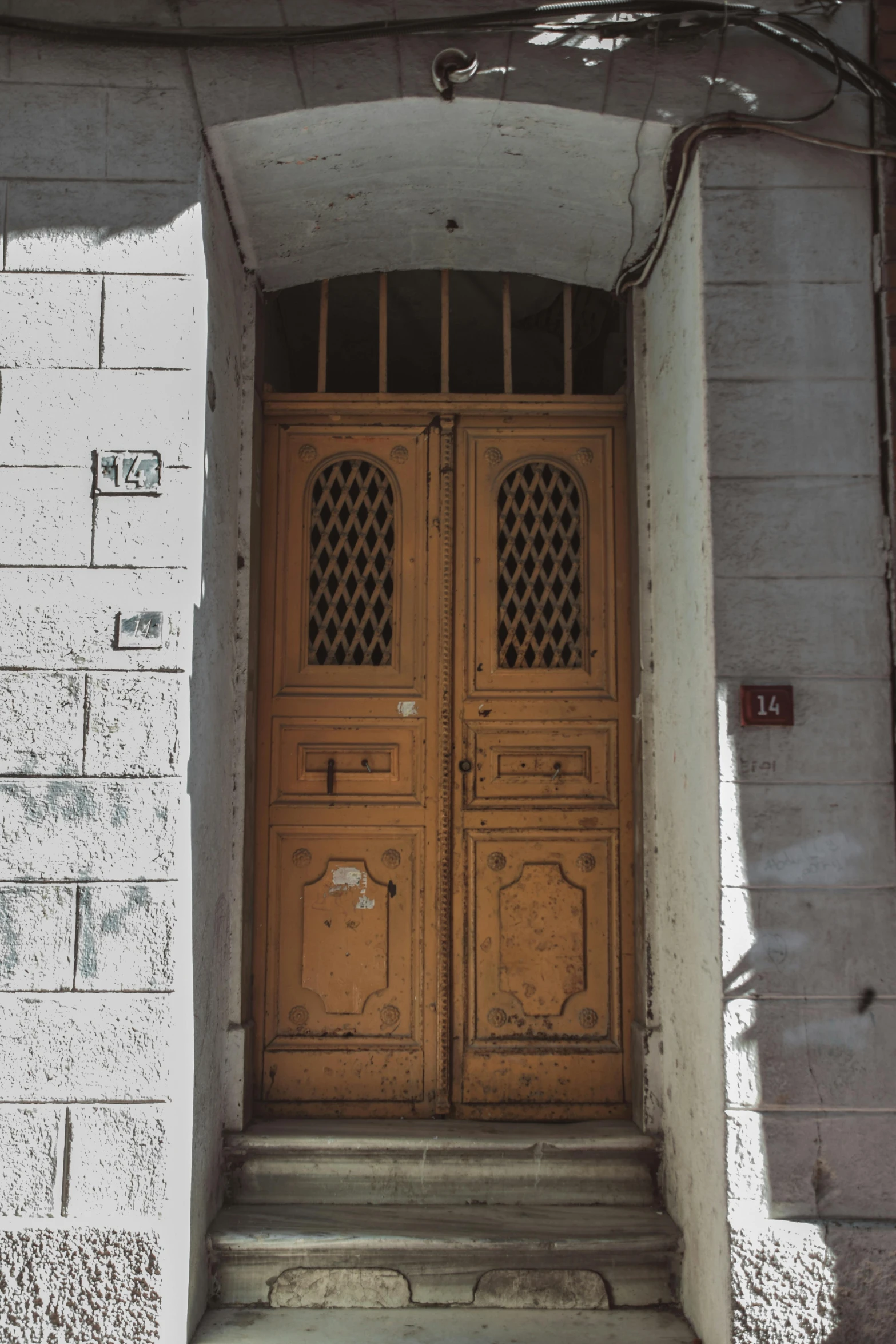 an old wooden door in a crumbling white building