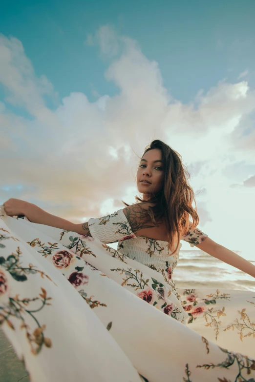 a woman posing on the beach wearing a dress