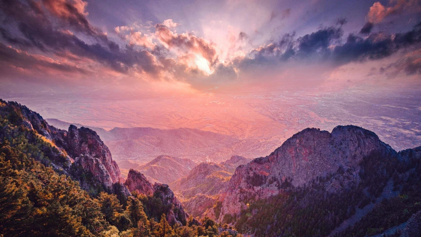 mountains covered with forests and hills under clouds at sunset