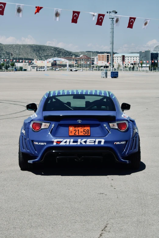 a blue racing car parked on top of a tarmac