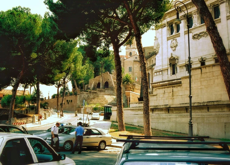 people standing around looking at cars on a city street