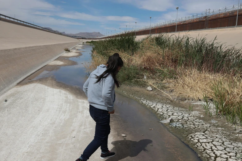 a girl is looking over the side of a road