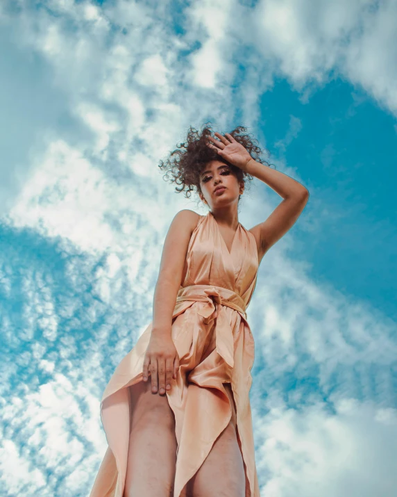 a person standing with her arms on her head