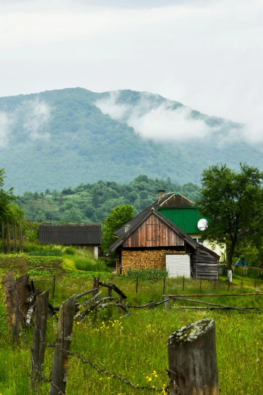 there is a barn with a green roof next to a lush green field