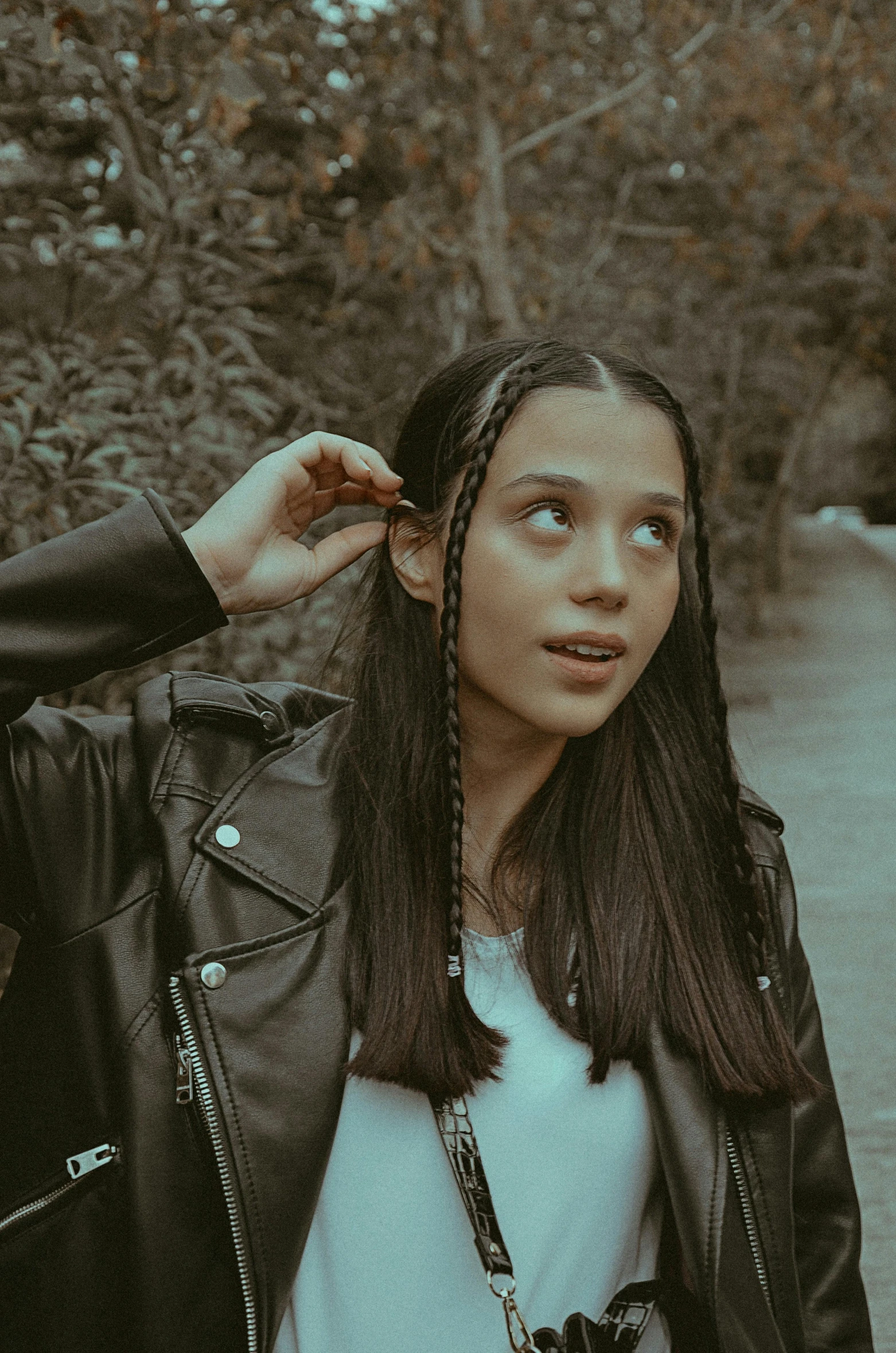 young female in black leather jacket posing on a path