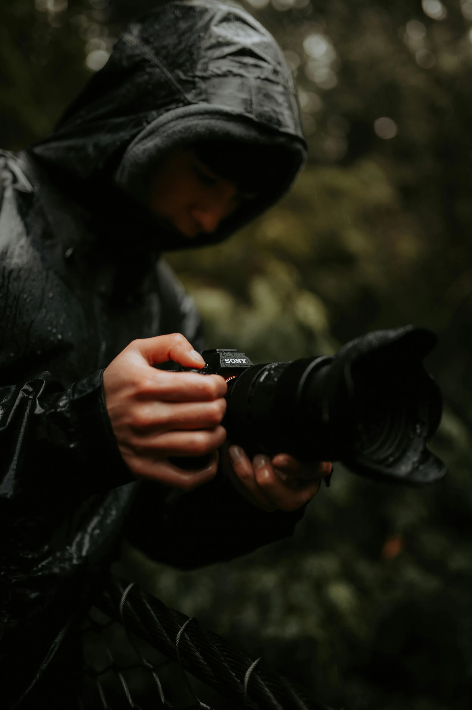 a young man dressed in black using a camera