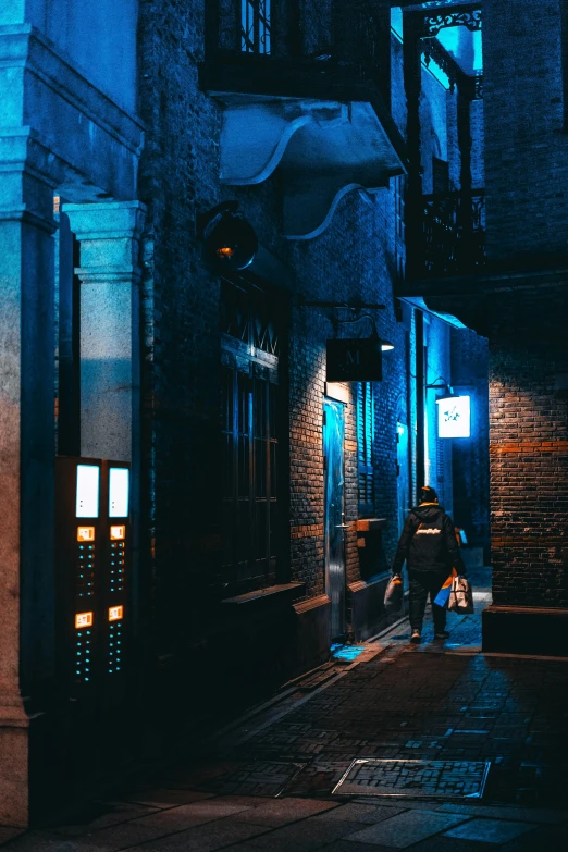 person walking down the street at night in the rain