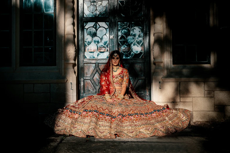 a woman in orange sitting on the steps of a house