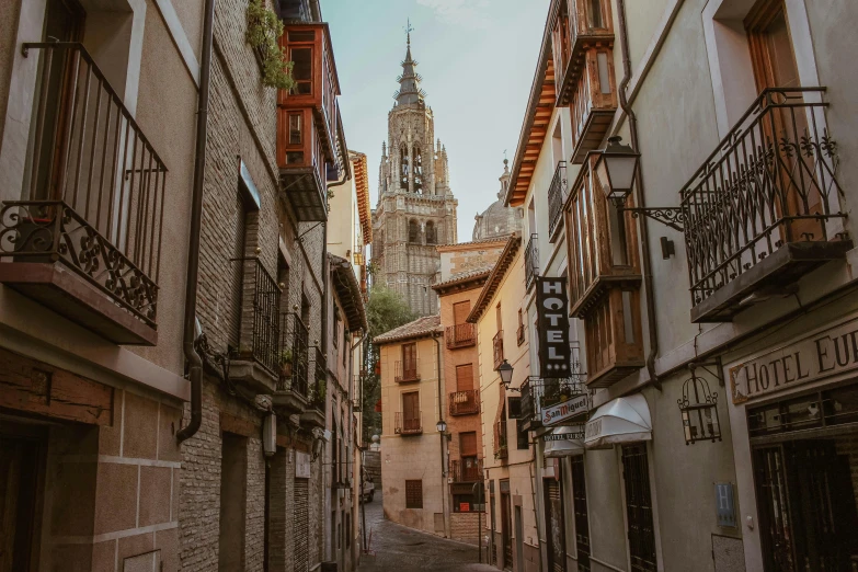 a cobble stone street with many buildings and railings