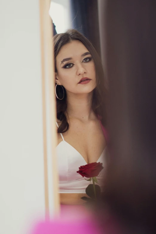 woman in white  and large flower on mirror