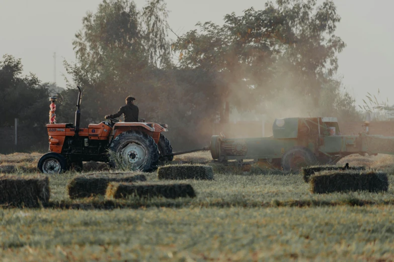 a person is using a tractor to cut hay