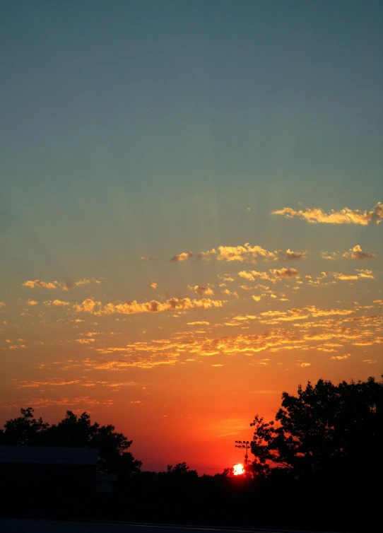 an orange sun is setting in the middle of a sky