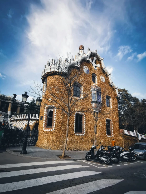 an old house made out of sticks is next to the road