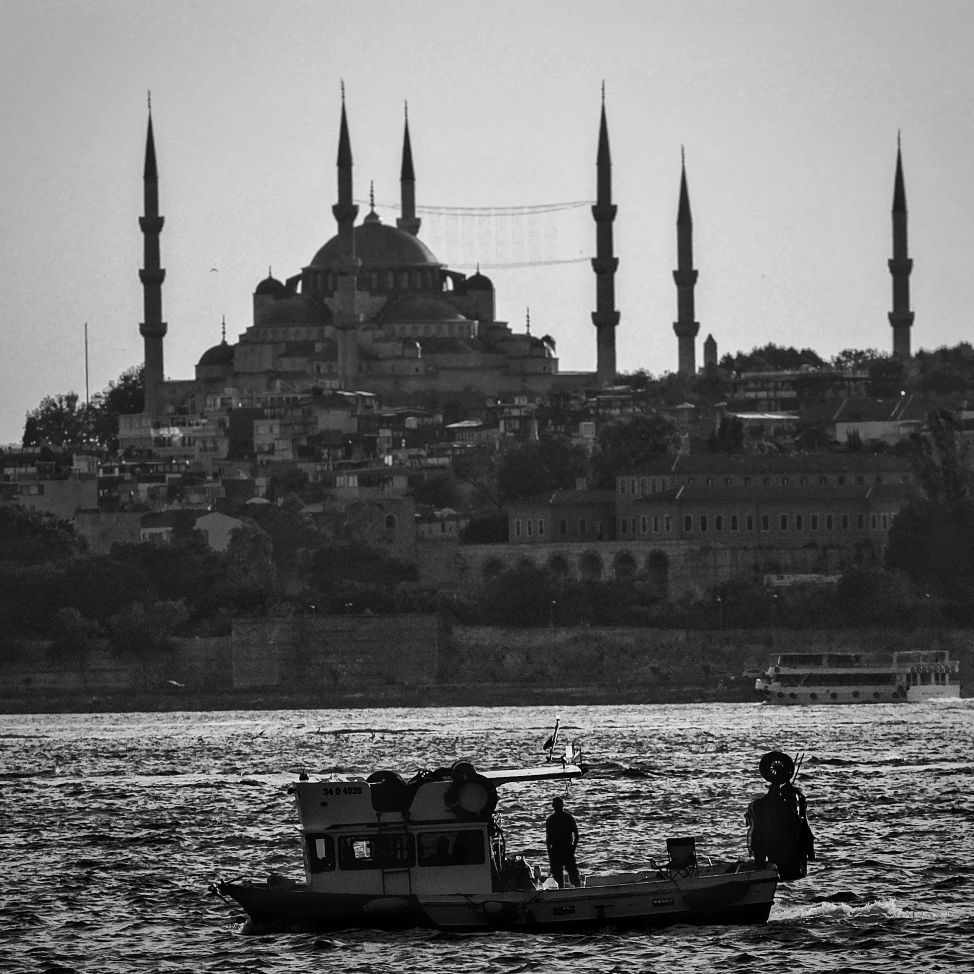 a small boat on water with a city in the back ground