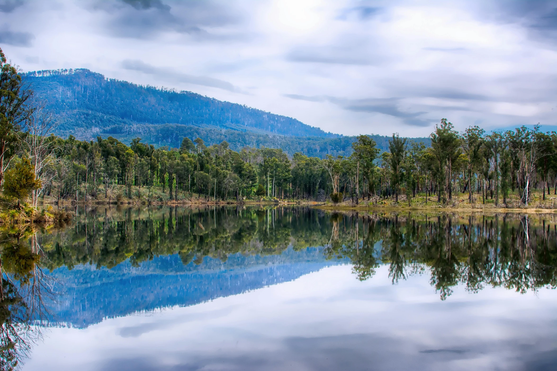 the reflection of a blue sky on a river