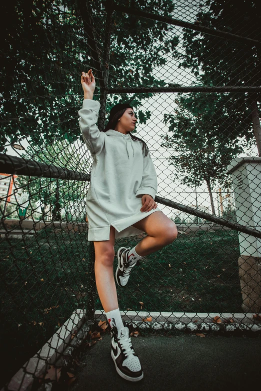 a person in a white dress jumping with their foot on a rail