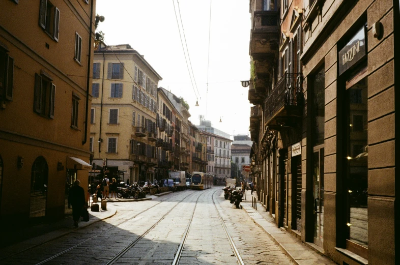 view down a street from a train track on a narrow road