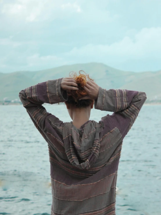 a young woman wearing a striped shirt over her shoulders