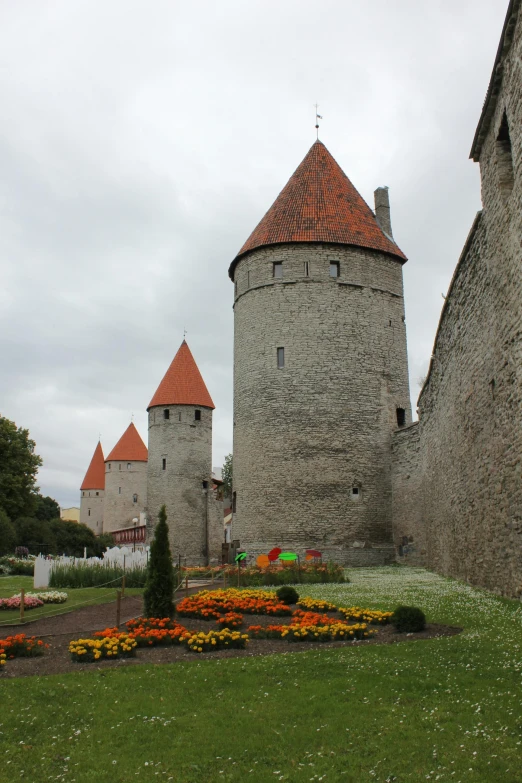 castle buildings in front of a garden and trees