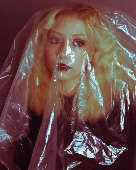 lady covered with plastic bags standing up with head and shoulders partially covering her head