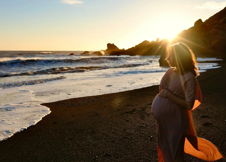 the woman is on the beach with a longboard in hand