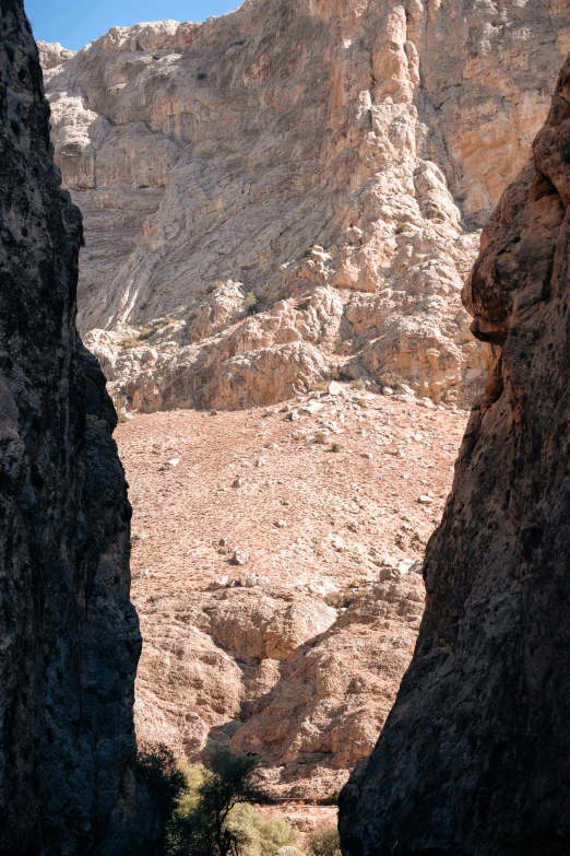 a narrow rocky path in the desert with mountains behind it