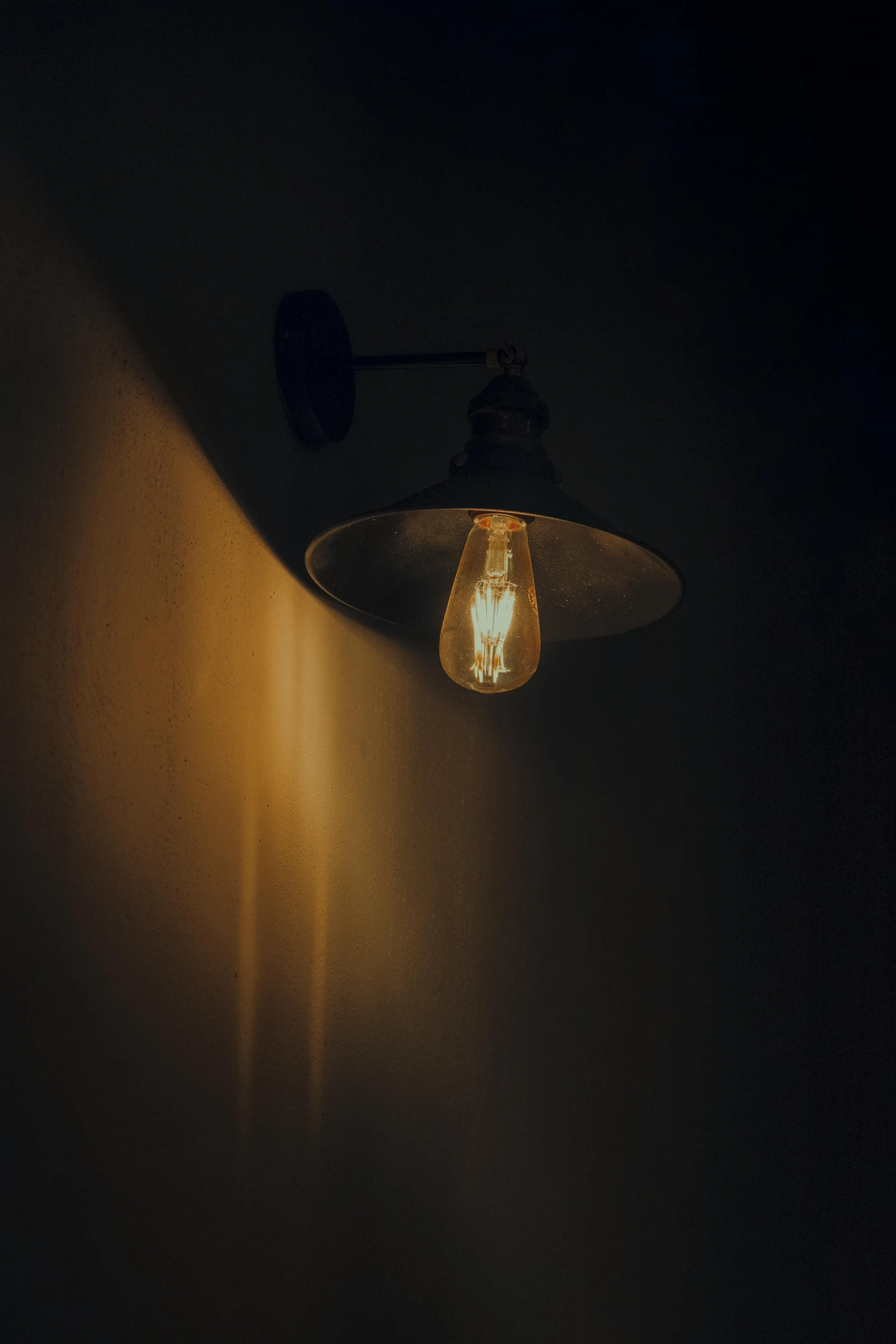 a wall mounted light sitting on a dark wall