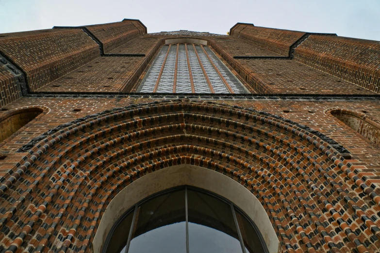 a tall brick building has a pointy roof