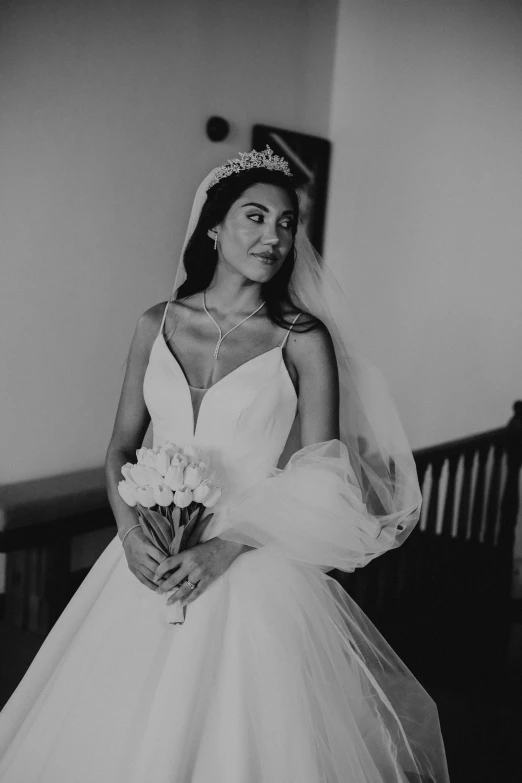 a bride holding her bouquet with the wind