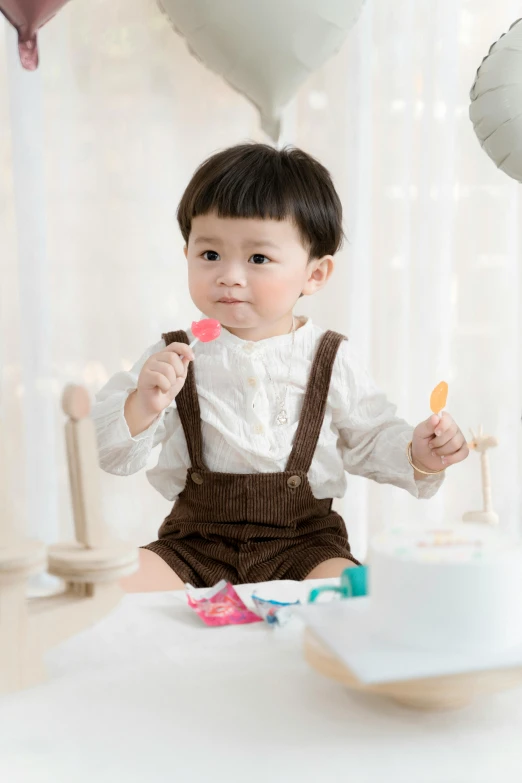 an infant sitting on a table and eating cake