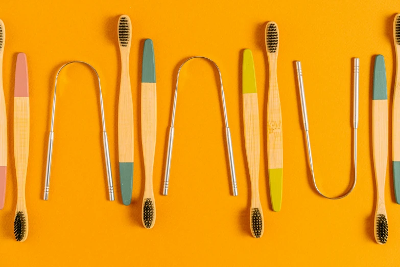 five different colored brushes on a yellow background