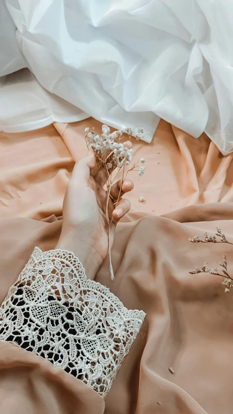 the hand of a woman who is holding flowers