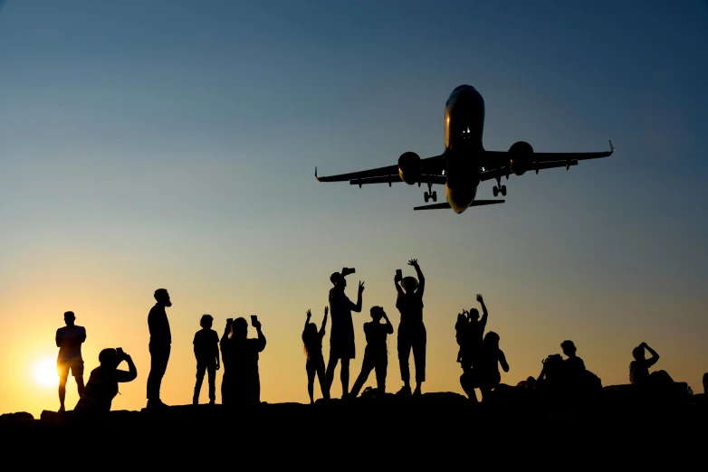 many people gather and stand in front of an airplane