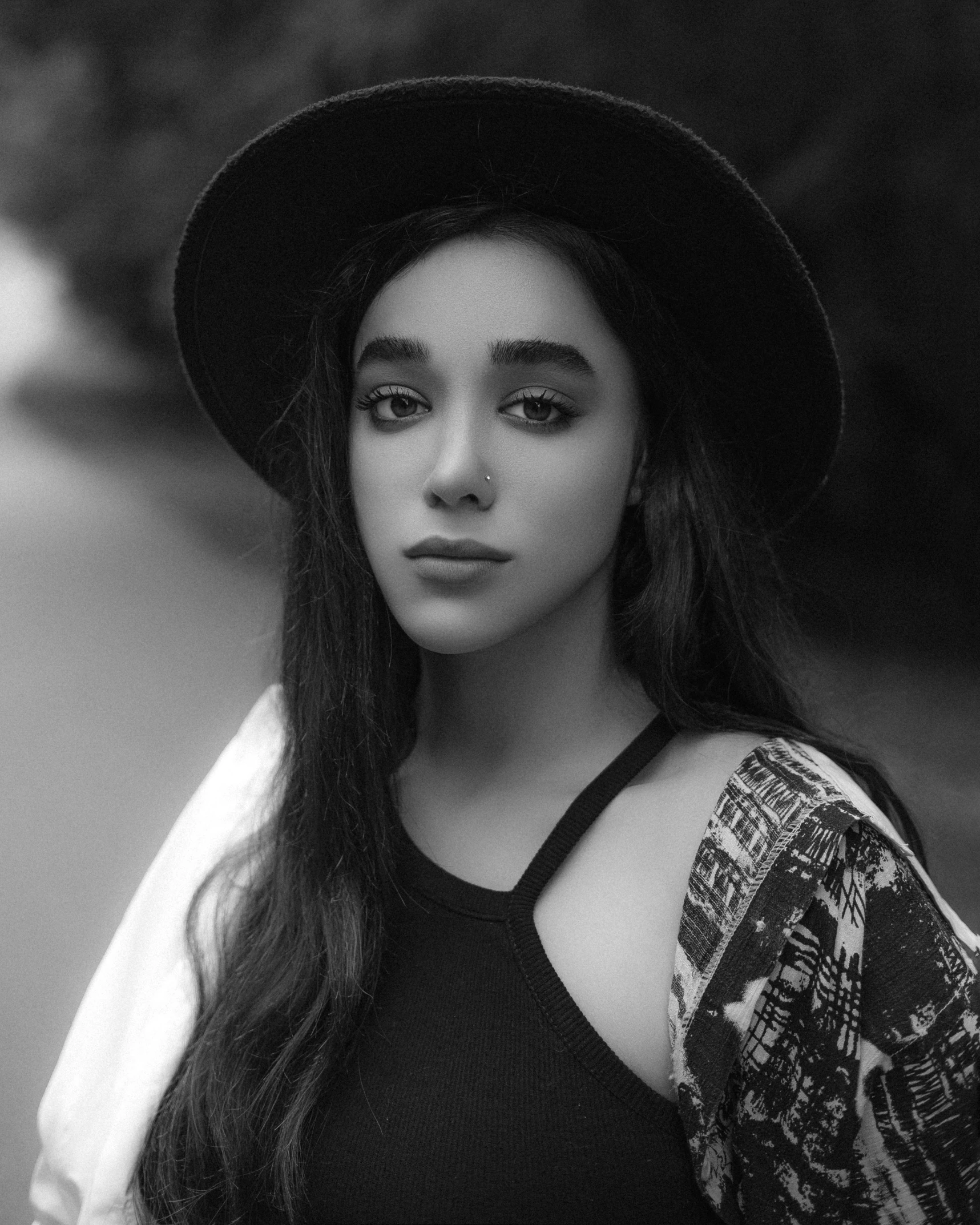 a beautiful young lady wearing a hat in black and white