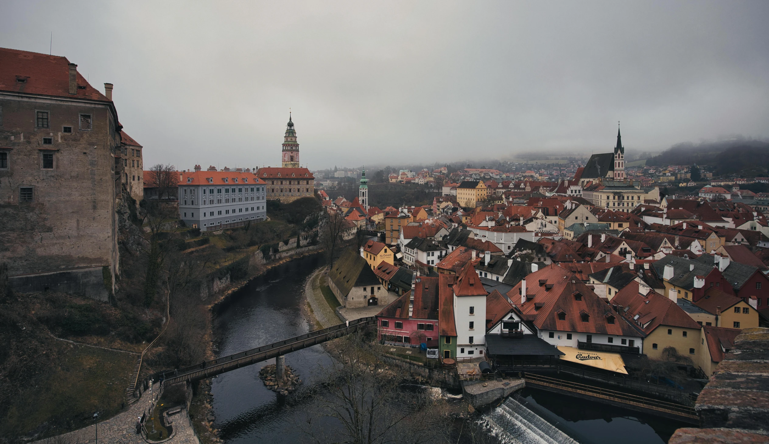 a large red tiled building next to a river