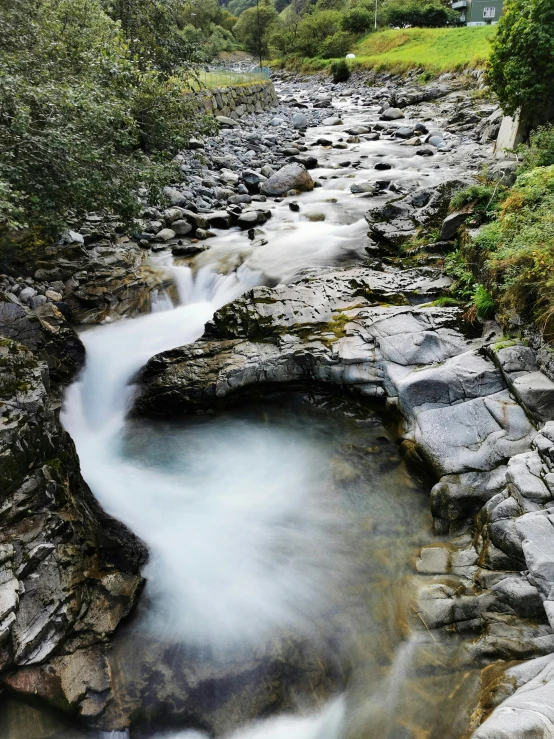 a mountain stream running into some rocks