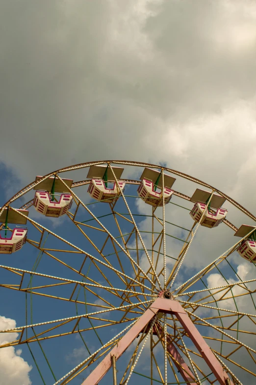 the ferris wheel is in front of a cloudy sky