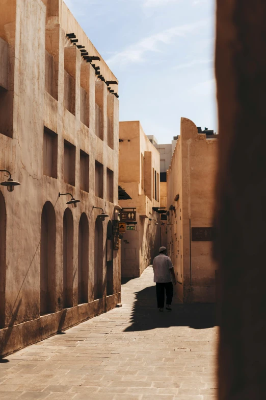 a man walking down a alleyway in a desert city