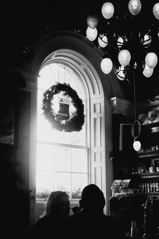 the christmas wreath is in front of the window